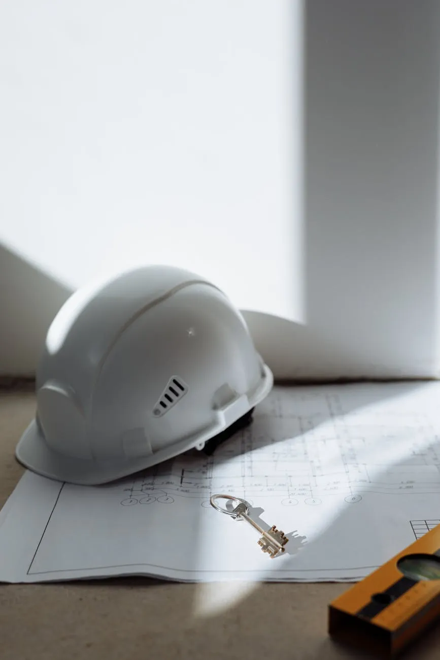 A hard hat and key on a site plan